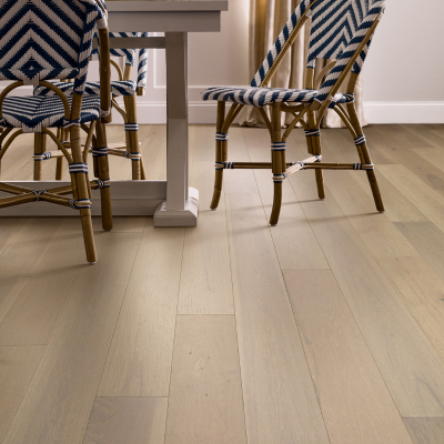 Dining room with light hardwood flooring, blue and white chevron-patterned chairs, and a light-colored dining table in a modern, airy space.